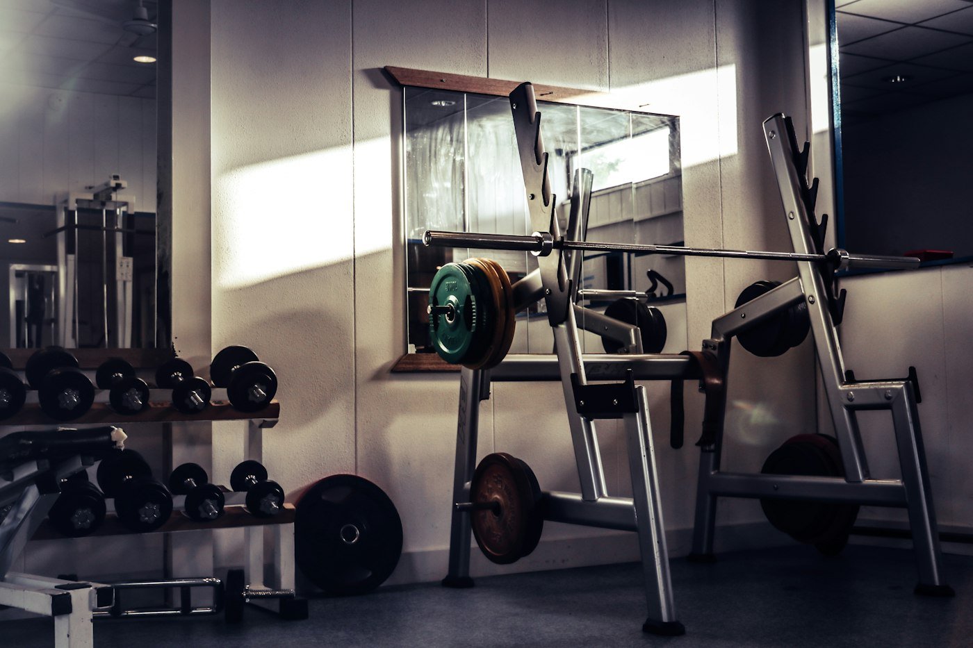 Loaded barbell resting on a squat rack in a gym