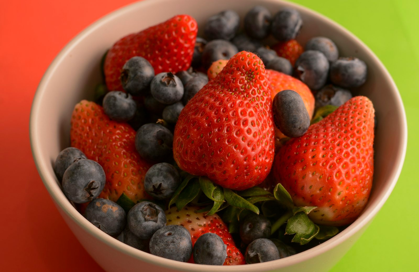 White bowl filled with blueberries and strawberries, foods rich in flavonoids