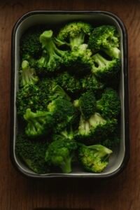 Dish of fresh green broccoli on a wooden table