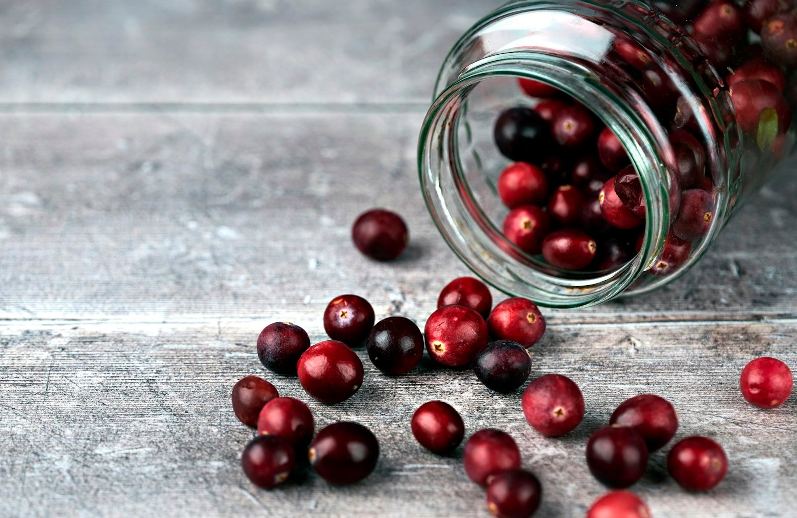 Red cranberries in a clear glass jar