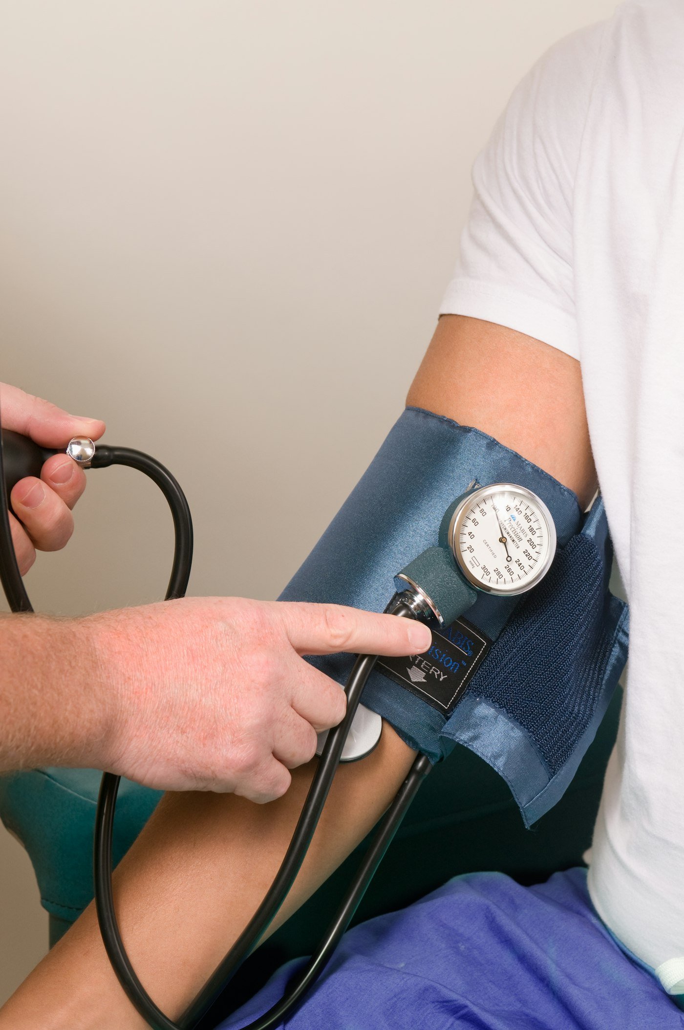 Doctor checking a patient's blood pressure with a cuff