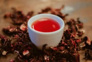 White ceramic cup filled with deep red hibiscus tea