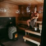 Man sitting on a bench inside a traditional wooden sauna