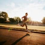 Man running on a track at sunrise, aerobic exercise that supports healthy blood flow and erectile function