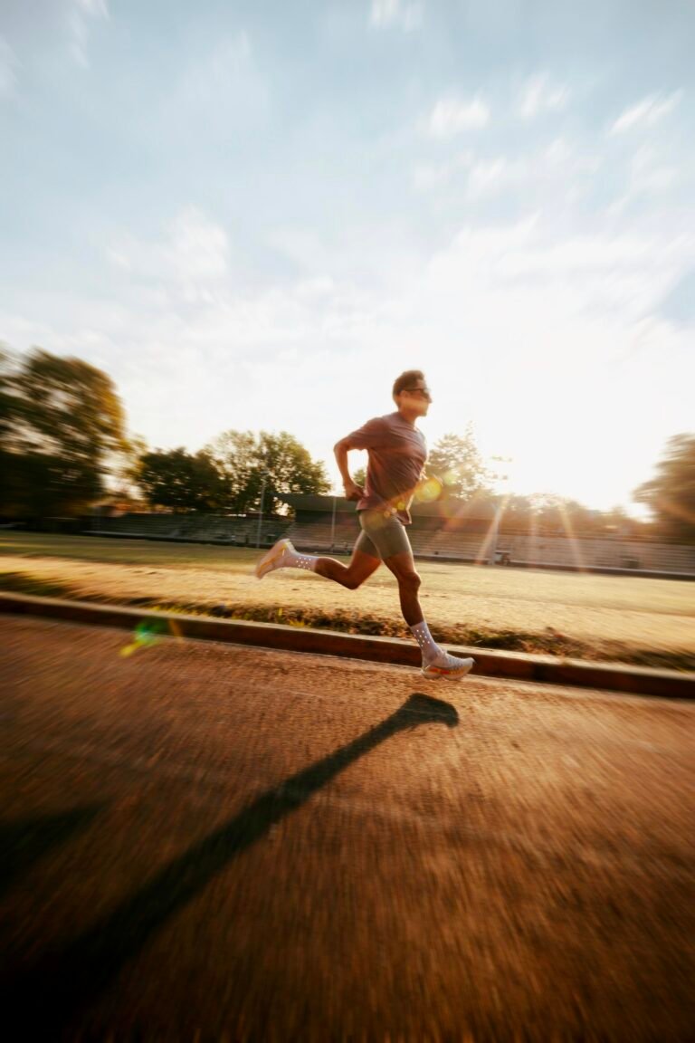 Man running on a track at sunrise, aerobic exercise that supports healthy blood flow and erectile function