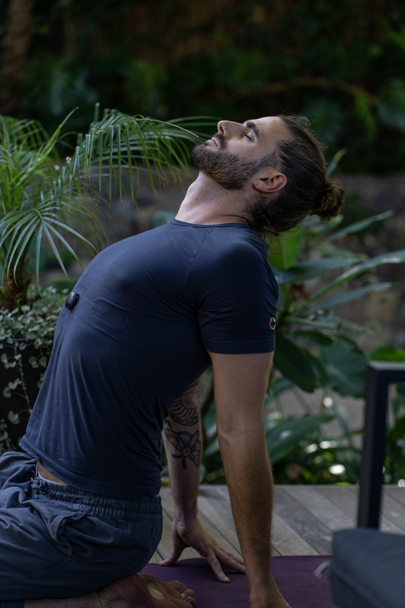 Man sitting on a yoga mat in a forest practicing slow breathing