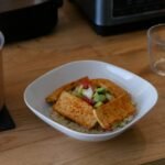 Bowl of quinoa topped with tofu and avocado, a plant-based protein meal for building muscle