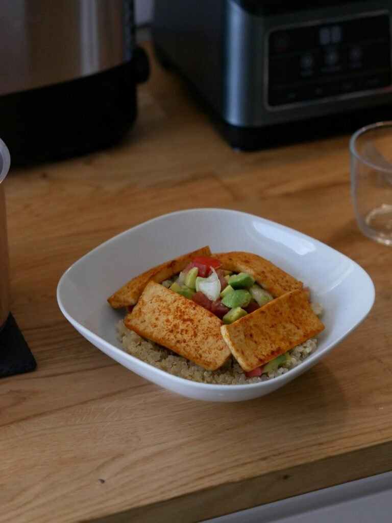 Bowl of quinoa topped with tofu and avocado, a plant-based protein meal for building muscle