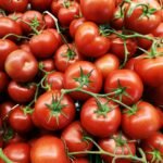 Ripe red tomatoes on a brown wooden table
