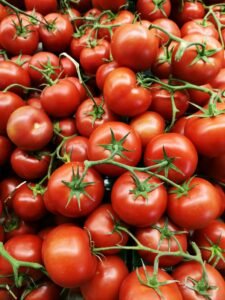 Ripe red tomatoes on a brown wooden table