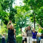Group of older adults practicing gentle exercise together outdoors in a park