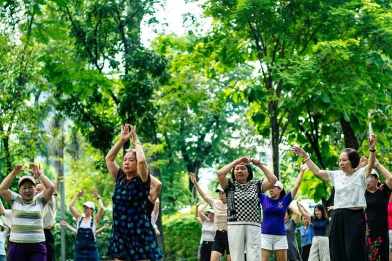 Group of older adults practicing gentle exercise together outdoors in a park