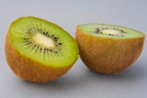 Slices of bright green kiwifruit on a white surface
