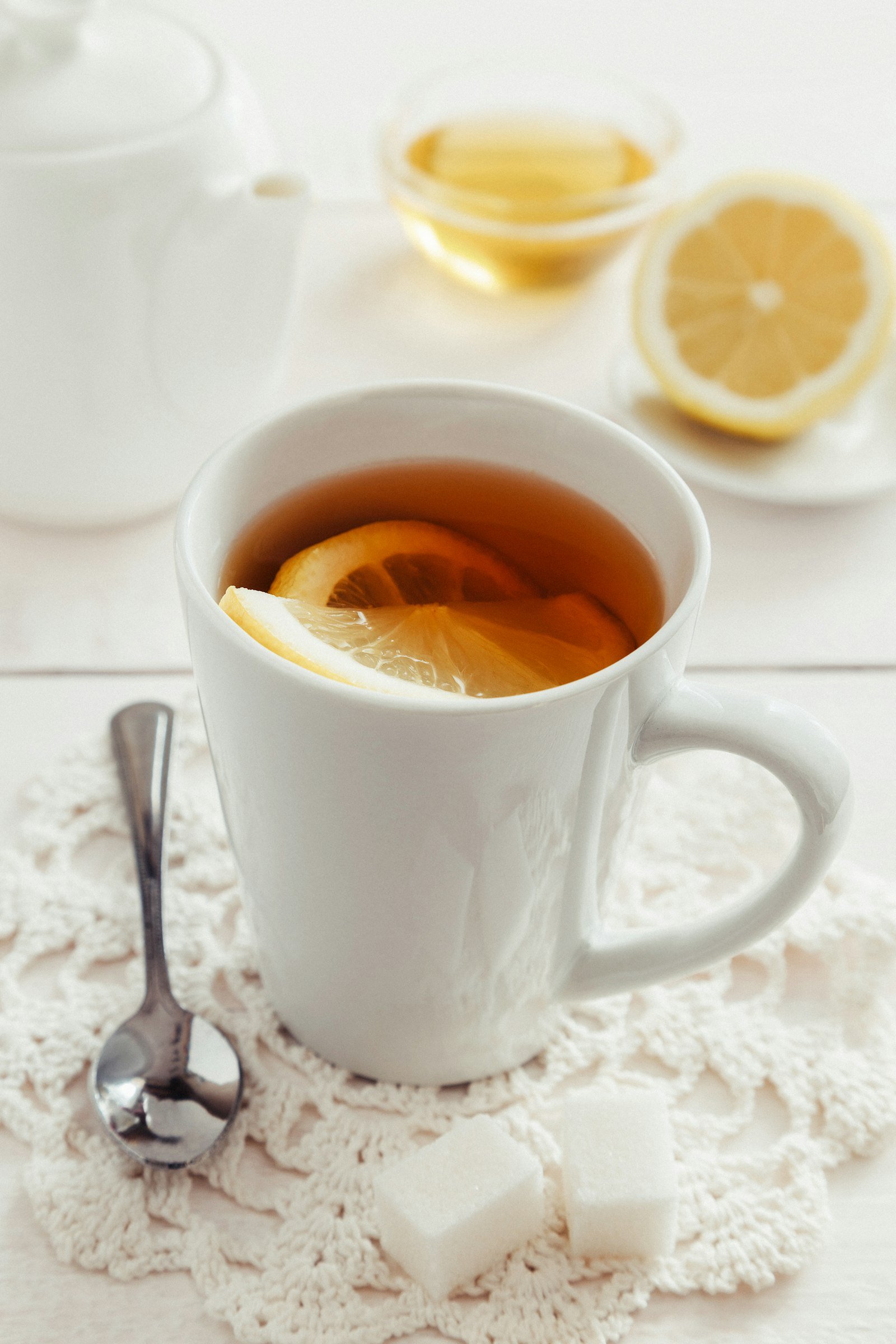 A warm cup of tea with a slice of lemon on a lace doily
