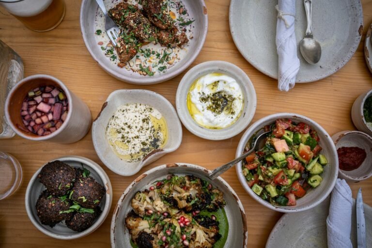 A wooden table topped with bowls of fresh whole foods