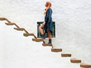 Woman climbing outdoor concrete stairs at a brisk pace